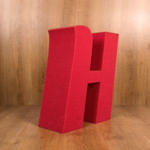 Inicial H en gran formato en color rojo en espuma de poliuretano. Tipo de letra Sansita. Foto de perfil.