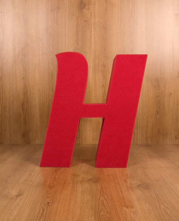 Inicial H en gran formato en color rojo en espuma de poliuretano. Tipo de letra Sansita. Foto frontal.