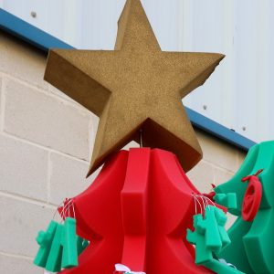Estrella dorada en lo alto de un árbol de navidad fabricado todo en espuma de poliuretano